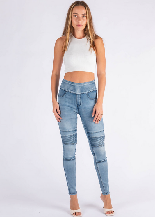 Woman wearing light blue jeans and a white top on a white background